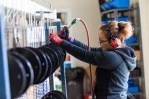 A global metal finishing worker works on metal parts.